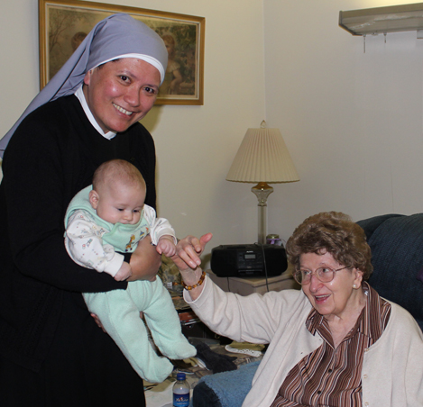 Mother Theresa Louisa, l.s.p., holds 2-month-old, Louie, our youngest event participant, as he visits with Helen, who will celebrate her 100th birthday in March.